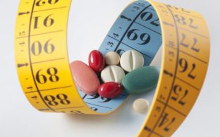 weight loss and diet pills surrounded by measuring tape